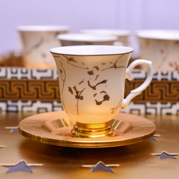 White coffee cup and saucer with gold line pattern