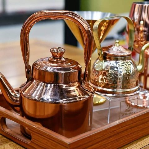 Copper tea kettle set on a wooden tray